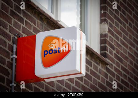 Bild eines Schildes mit dem Logo von PostNL, aufgenommen in ihrem Büro im Stadtzentrum von Vaals. PostNL, vormals TNT N.V., ist eine Post-, Paket- und E-Commerce-gesellschaft Stockfoto