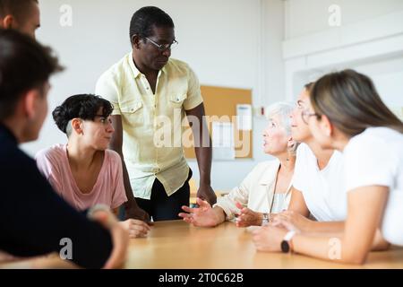 Multirassische gemischte Altersgruppe, die an der Erwachsenenbildungsklasse mit afroamerikanischem Tutor teilnimmt Stockfoto
