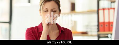 Weibliche Mitarbeiterin hustet, wenn sie am Arbeitsplatz am Schreibtisch sitzt Stockfoto
