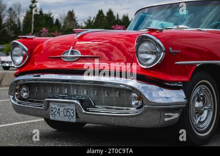 Frontfoto eines klassischen roten Luxuswagens. Farbdetails auf dem Scheinwerfer eines Oldtimers. Vor einem alten amerikanischen Auto in einer Straße von Vancouver Canad Stockfoto