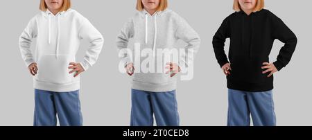 Vorlage eines weißen, heidekrauten, schwarzen Hoodies für ein Mädchen, Hände an den Seiten, Set von Kinderhemden, Vorderansicht, isoliert auf Hintergrund. Produktfotografie für Stockfoto