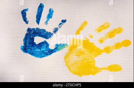 Bunte Drucke gelb-blau bemalter Kinderhände. Kreatives patriotisches Konzept. Ukrainische Kinder sind gegen Krieg. Unterstützung Der Ukraine Stockfoto