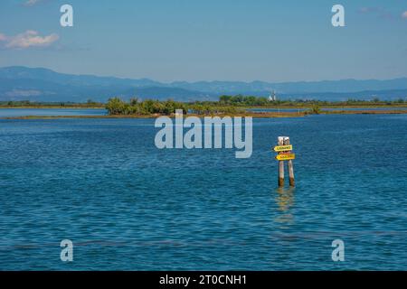 Ein Wegweiser nach Lignano und Aquileia im Grado-Abschnitt der Lagune von Marano und Grado in Friaul-Julisch Venetien, Nordosten Italiens Stockfoto