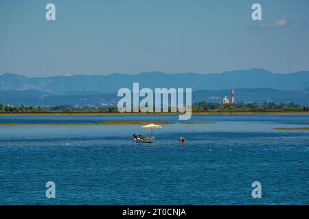 Angeln von Cockles mit einem Schnellboot im Abschnitt Grado der Lagune von Marano und Grado in Friaul-Julisch Venetien, Nordost-Italien. Stockfoto