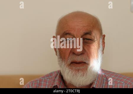 Ein bärtiger alter Mann schaut glücklich zu Stockfoto