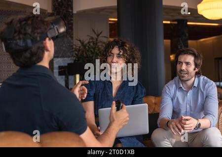 Geschäftsfrau, die ein Tablet mit Gesten von Kollegen verwendet, indem sie einen Virtual-Reality-Simulator trägt Stockfoto