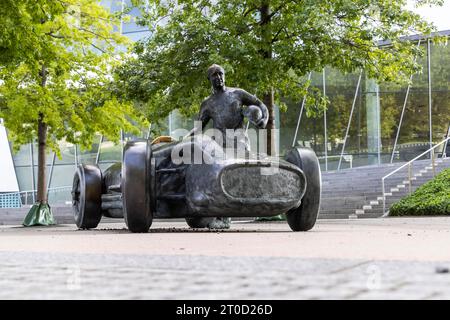 Das Denkmal vor dem Mercedes-Benz Museum erinnert an den legendären Rennfahrer Juan Manuel Fangio in seinem Silberpfeil W 196 R von 1954 Stockfoto