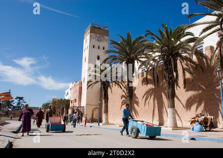 Leute, die an den Mauern der Medina (Altstadt) vorbeilaufen. Essaouira, Marokko. Stockfoto