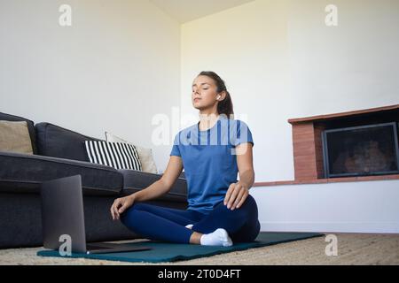 Frau meditiert zu Hause nach dem Training Entspannung Stockfoto