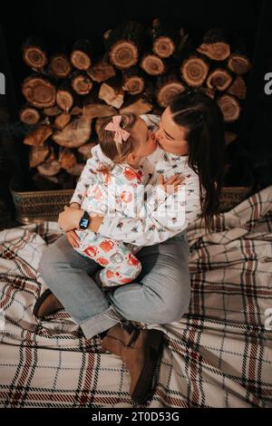 Mutter und Tochter kuscheln sich in Urlaub PJs am Kamin Stockfoto