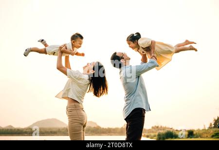 Eine glückliche Familie genießt verspielte Momente auf einem Sommerfeld Stockfoto