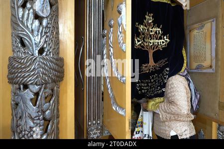 Eine religiöse jüdische Frau betet, während sie ihren Kopf in eine Torah-Arche legt, die Torah-Schriftrollen in einer Synagoge auf der israelischen Seite des Patriarchengrabes enthält, bekannt unter dem biblischen Namen Cave of Machpela und den Muslimen als al-Haram al-Ibrahimi. ein Ort, der als letzte Ruhestätte des Propheten Abraham gilt, einer heiligen Figur für Juden und Muslime, im Herzen der Altstadt in Hebron, Israel. Stockfoto