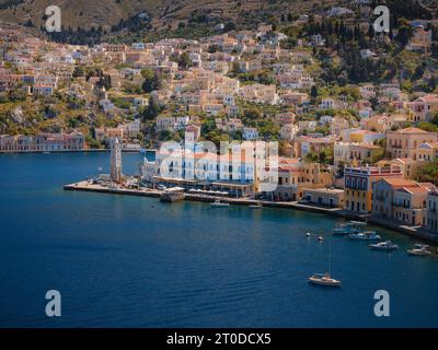 Symi Island, Griechenland. Griechenland Inseln Urlaub von Rhodos in der Ägäis. Farbenfrohe neoklassizistische Häuser in der Bucht von Symi. Hintergrund der Urlaubsreise. Ansicht f Stockfoto