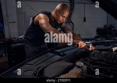 Fokussierter afroamerikanischer Mann, der die Schrauben herausdreht Stockfoto