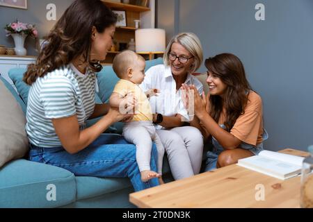 Großmutter, Mutter und Baby zu Hause zum Spielen, zum Spaß und zum Zusammenleben im Wohnzimmer. Liebe, glückliche Familie Tante und Mutter eines Kindes mit oma Stockfoto