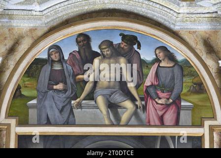 Fano (Italien, Marken. Provinz Pesaro-Urbino). Kirche Santa Maria Nuova, Pietro Vannucci bekannt als Il Perugino, Altar von Fano (Jungfrau und Kind mit den Heiligen Johannes dem Täufer, Ludwig von Toulouse, Franz von Assisi, Peter und Maria Magdalena; Pietà im Cymatium mit dem Heiligen Joseph von Arimathea und St. Nicodemus), Öl auf Platte, 1488-89 Stockfoto