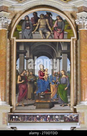 Fano (Italien, Marken. Provinz Pesaro-Urbino). Kirche Santa Maria Nuova, Pietro Vannucci bekannt als Il Perugino, Altar von Fano (Jungfrau und Kind mit den Heiligen Johannes dem Täufer, Ludwig von Toulouse, Franz von Assisi, Peter und Maria Magdalena; Pietà im Cymatium mit dem Heiligen Joseph von Arimathea und St. Nicodemus), Öl auf Platte, 1488-89 Stockfoto
