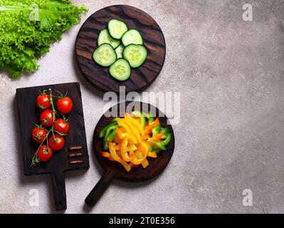 Essenshintergrund Holzbretter und frisches Gemüse für Salat Stockfoto
