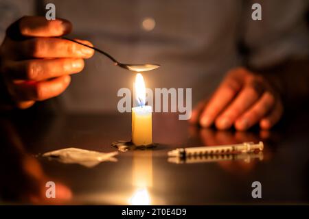 Spritze, Kerze und Heldin eines Junkies Stockfoto