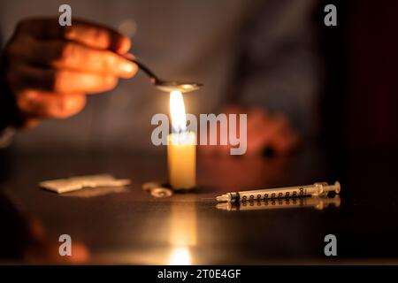 Spritze, Kerze und Heldin eines Junkies Stockfoto