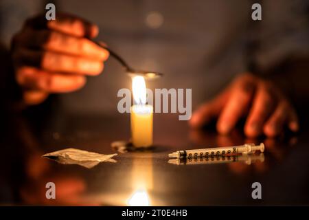 Spritze, Kerze und Heldin eines Junkies Stockfoto