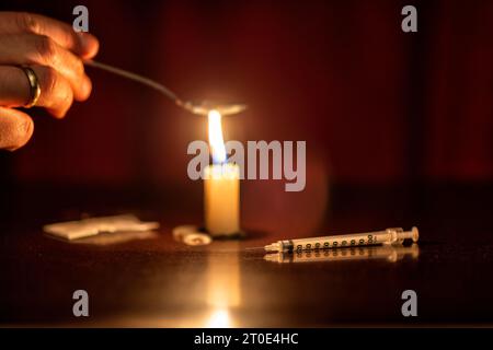 Spritze, Kerze und Heldin eines Junkies Stockfoto