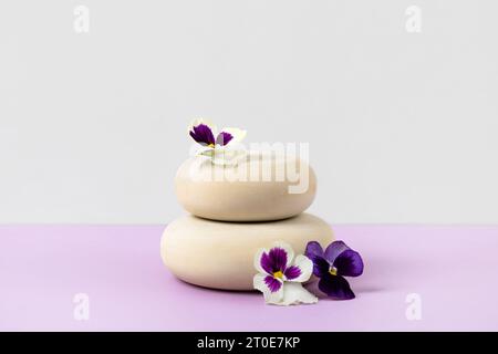 Hölzerner runder Podiumsockel kosmetische Schönheitsproduktpräsentation leeres Modell auf lilafarbenem Pastellhintergrund mit weißen Blumen. Stockfoto