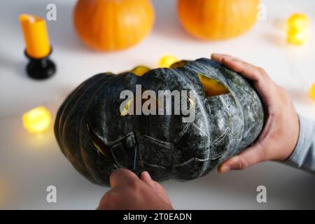 Eine Nahaufnahme der Hände eines Mannes, der die Dekoration für Halloween vorbereitet. Stockfoto