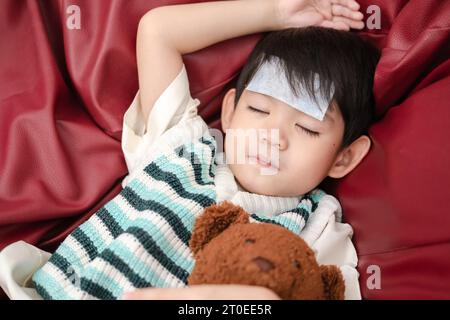 Sie war krank und hatte einen fiebersenkenden Fleck auf der Stirn. Sie lag auf dem Bett. Stockfoto