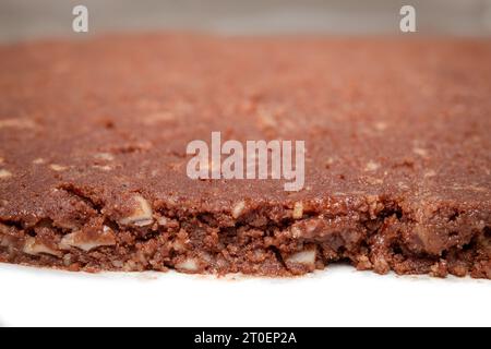 Ausgerollter Schokoladen-Keksenteig auf Pergamentpapier. Glutenfreies Mandelmehl Schokoladenkeks. Hintergrund zum Backen von Weihnachtskeksen. Schweizer Rezept „Basler B Stockfoto