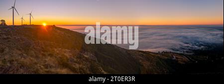 Windturbinen bei Sonnenuntergang über einem Hügel in Arouca, Portugal. Stockfoto