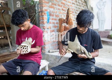 Junge Männer, die traditionelle mythische Tiermasken aus Ton herstellen, Majuli, Assam, Nordosten Indiens Stockfoto
