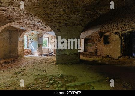 Gewölbter roter Ziegelkerker unter dem alten Herrenhaus. Stockfoto
