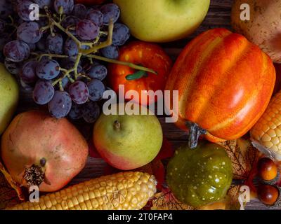 Stillleben im Herbst. Verschiedene Früchte, Gemüse und Kürbis auf dem Holztisch Stockfoto