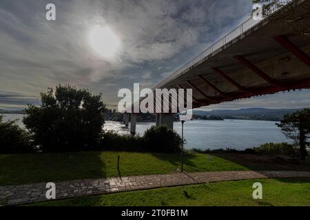 Ein ruhiger Weg über Wasser: Red and White Bridge in einem grünen Park Stockfoto