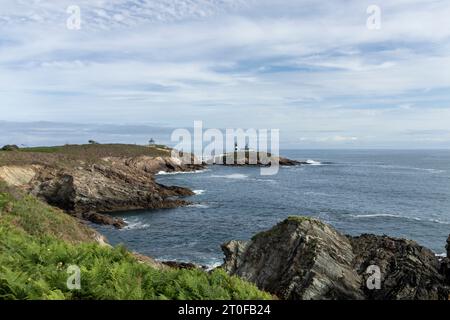 Leuchtturm auf einer Klippe: Leuchtturm inmitten des Deep Blue Sea und der zerklüfteten Felsen Stockfoto