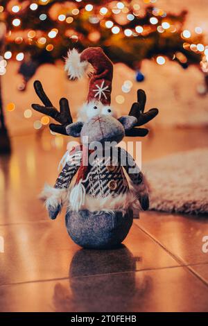 Das Weihnachtshirsch-Spielzeug liegt auf dem Boden. Weihnachtsdekoration. Santa Rentier mit rotem Hut. Winterferien. Neujahrsfeier. Weihnachtsbaum und Hirschpuppe. C Stockfoto