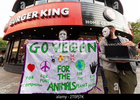 Tierschützer protestieren vor Burger King am Leicester Square, London, Großbritannien. Gehen Sie zu einer veganen Botschaft auf das Banner Stockfoto