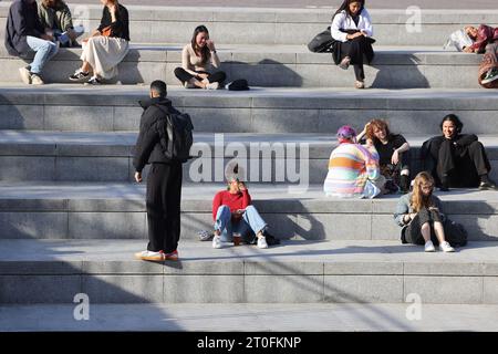 Ungewöhnlich warmes Wetter in London, hier am Granary Square, wo die Menschen sich in der Sonne entspannen, im Kings Cross im Norden Londons, Großbritannien Stockfoto