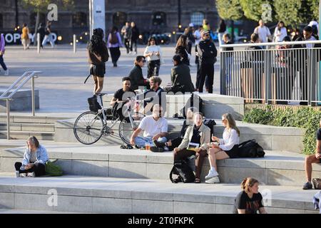 Ungewöhnlich warmes Wetter in London, hier am Granary Square, wo die Menschen sich in der Sonne entspannen, im Kings Cross im Norden Londons, Großbritannien Stockfoto