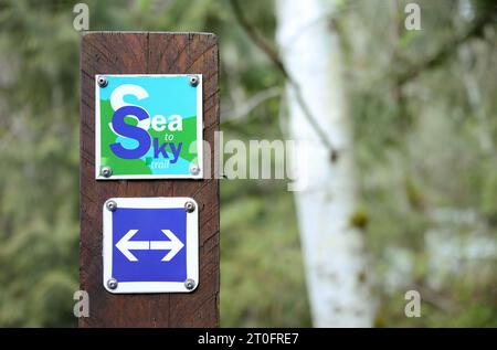 Sea to Sky Trail Pfosten mit Pfeil und unscharfem Wald. Beliebter Wanderweg im Lynn Canyon, der nach Baden Powell führt. Für Wanderer, Läufer und Hundegänge Stockfoto