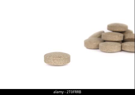 Runde Wafer-Tablette mit unscharfem Stapel. Mehrere grün strukturierte gepresste Tabletten oder Pillen. Isolierte Multivitamine für Hunde, Nahrungsergänzungsmittel. Selektiv Stockfoto