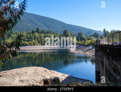Malerischer See mit Damm und Bergen im Herbst. Liefert Frischwasser in die Region Vancouver. Wassermangel oder Dürre. North Vancouver, Capilano Stockfoto