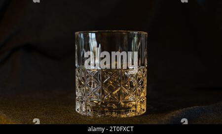 Ein einsames Glas Whiskey, vor einem eleganten grau-schwarzen Hintergrund, verkörpert Raffinesse und die Essenz des kontemplativen Stockfoto