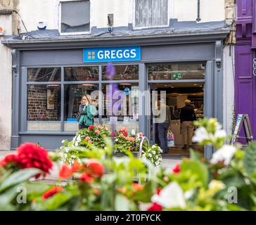 Wells, Großbritannien, 4. August 2023: Eintritt zu Greggs Bäckern mit Blumen vor der Tür Stockfoto