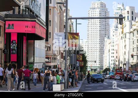 Madrid, Spanien. Oktober 2023. Touristen und Fußgänger spazieren auf dem Bürgersteig der Calle Gran, wo die Straße vor dem spanischen Nationalfeiertag in Madrid mit einer spanischen Flagge geschmückt ist. Der Madrider Stadtrat installierte Banner und die spanische Flagge zur Feier des spanischen Nationalfeiertags, der jeden 12. Oktober gefeiert wird. Der Tag ist auch bekannt als Dia dela Hispanidad. Quelle: SOPA Images Limited/Alamy Live News Stockfoto