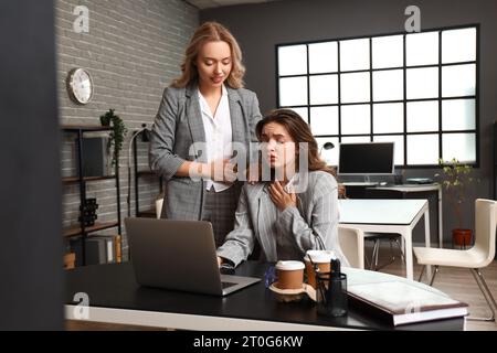 Frau, die ihrem Kollegen hilft, der im Amt eine Panikattacke hat Stockfoto