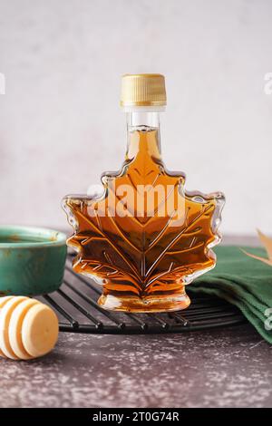 Flasche leckerer Ahornsirup auf dem Tisch Stockfoto