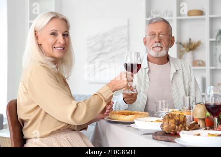 Reifes Paar beim Abendessen am Festtisch am Thanksgiving Day Stockfoto