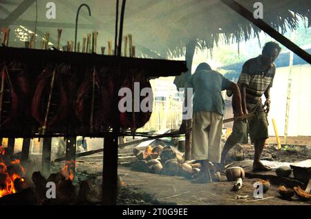 Ein Arbeiter hält die gleiche Verteilung von Kokosnussschalen aufrecht, die als Brennstoff zum Räuchern von Bonito-Thunfischfleisch in einer Heimindustrie in Bitung, Nord-Sulawesi, Indonesien, verwendet werden. Der Beitrag der indigenen Bevölkerung zur technologischen Innovation bietet eine breite Palette von Optionen für die Bewältigung unter anderem der Ernährungssicherheit, so der Bericht des Zwischenstaatlichen Ausschusses für Klimaänderungen (IPCC) aus dem Jahr 2023. Der im Volksmund als Cakalang Fufu bekannte geräucherte Thunfisch gilt als exotisches einheimisches Essen, ein Teil der Produktion von Bonito-Thunfischen, die eine der wichtigsten wirtschaftlichen Aktivitäten in Bitung City ist. Stockfoto